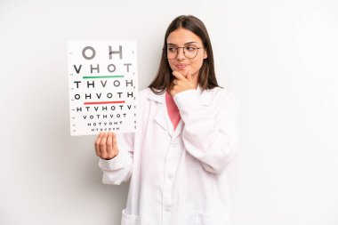 Güzel bir kadın mutlu, kendinden emin ve elleri çenesinde gülümsüyor. optik görüş testi konsepti