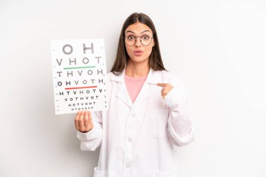 Güzel bir kadın mutlu hissediyor ve heyecanla kendini işaret ediyor. optik görüş testi konsepti