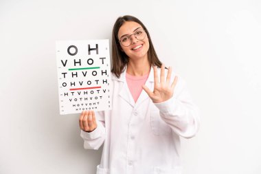 Güzel bayan gülümsüyor ve arkadaş canlısı görünüyor, beş numarayı gösteriyor. optik görüş testi konsepti