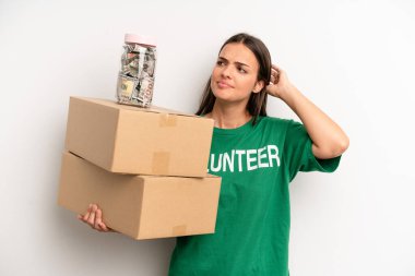 pretty woman feeling puzzled and confused, scratching head. volunteer and donation concept
