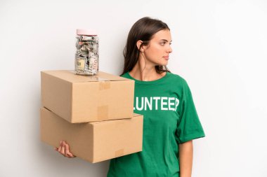 pretty woman on profile view thinking, imagining or daydreaming. volunteer and donation concept