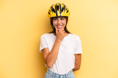 pretty woman smiling with a happy, confident expression with hand on chin. bike sport concept
