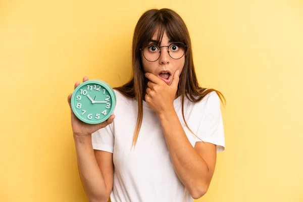 Hispanic Woman Mouth Eyes Wide Open Hand Chin Alarm Clock — Stockfoto