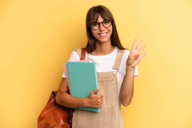 Güzel bayan gülümsüyor ve arkadaş canlısı görünüyor, dört numarayı gösteriyor. Üniversite öğrencisi konsepti