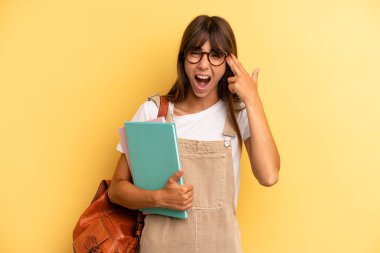 Güzel bir kadın mutsuz ve stresli görünüyor, intihar jesti silah işareti yapıyor. Üniversite öğrencisi konsepti