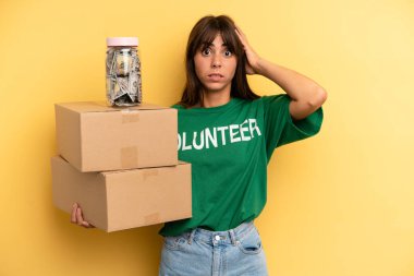 pretty woman feeling stressed, anxious or scared, with hands on head. volunteer and donation concept