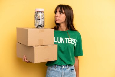 pretty woman on profile view thinking, imagining or daydreaming. volunteer and donation concept