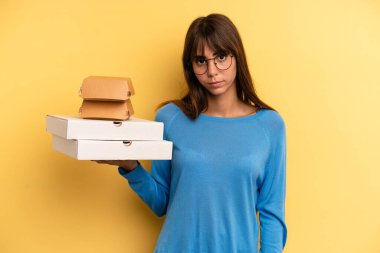 pretty woman feeling sad, upset or angry and looking to the side. take away fast food concept