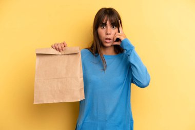 pretty woman looking surprised, realizing a new thought, idea or concept. take away fast food concept
