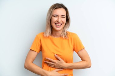 Genç ve güzel bir kadın komik bir şakaya yüksek sesle gülüyor, mutlu ve neşeli hissediyor, eğleniyor.