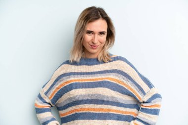 Genç ve güzel bir kadın gururlu, kendinden emin, havalı, küstah ve kibirli görünüyor, gülümsüyor, başarılı hissediyor