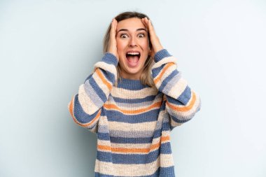 Genç ve güzel bir kadın el ele tutuşuyor, ağzı açık, son derece şanslı, şaşırmış, heyecanlı ve mutlu.