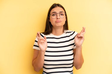 Genç ve güzel bir kadın endişeyle dua ediyor ve endişeli bir bakışla iyi şanslar diliyor.