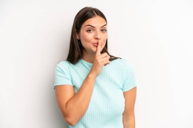 Genç ve güzel bir kadın sessizlik ve sessizlik istiyor, parmaklarıyla ağzının önünde işaret ediyor, 