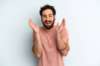 Genç, sakallı, şok olmuş, heyecanlı, gülen, şaşırmış ve mutlu bir adam. Beklenmedik bir sürpriz yüzünden.