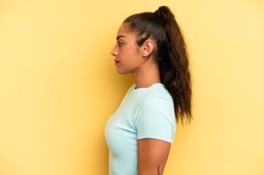 Latin kökenli güzel kadın profil görünümünde uzayı kopyalamaya çalışıyor, düşünüyor, hayal ediyor ya da hayal kuruyor.