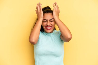 İspanyol güzel kadın stresli ve endişeli, depresif ve hayal kırıklığına uğramış hissediyor, iki elini de başa kaldırıyor.