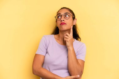 İspanyol bakışlı güzel bir kadın, şüpheli bir ifadeyle merak ediyor, yukarı ve yana bakıyor