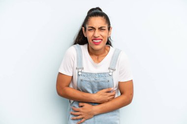 İspanyol güzel bir kadın endişeli, hasta, hasta ve mutsuz hissediyor. Ağrılı bir mide ağrısı veya grip geçiriyor.