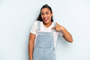 İspanyol güzel kadın mutlu, gururlu ve şaşırmış görünüyor, neşeli bir şekilde kendini gösteriyor, kendinden emin ve kibirli hissediyor.