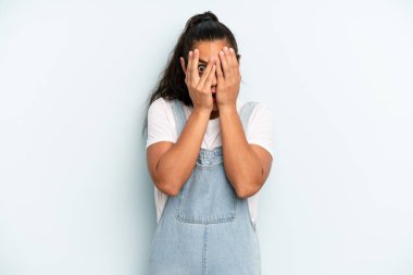 İspanyol güzel kadın korkmuş ya da utanmış hissediyor, gözleri yarı kapalı ya da elleri kapalı dikizliyor ya da dikizliyor.