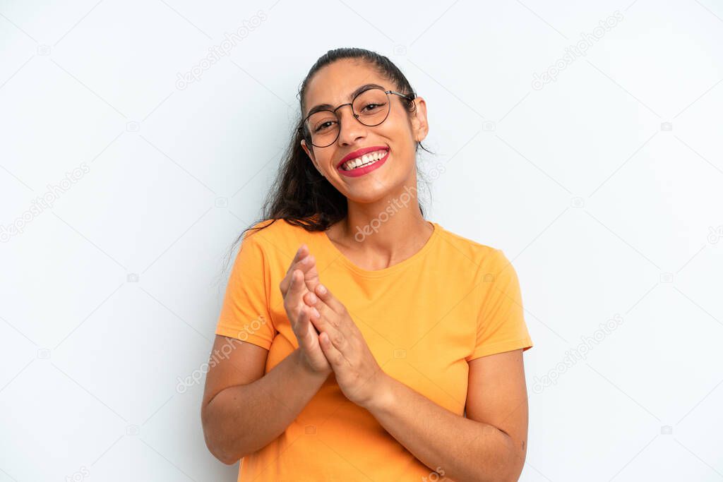 hispanic pretty woman feeling happy and successful, smiling and clapping hands, saying congratulations with an applause