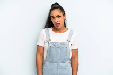hispanic pretty woman feeling puzzled and confused, with a dumb, stunned expression looking at something unexpected