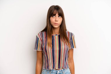 İspanyol güzel kadın şaşkın ve şaşkın görünüyor, merak ediyor veya bir sorunu çözmeye çalışıyor ya da düşünüyor.