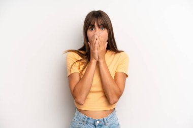 Hispanik güzel kadın endişeli, üzgün ve korkmuş hissediyor, elleriyle ağzını kapatıyor, endişeli ve berbat görünüyor.
