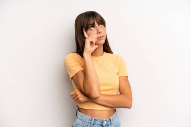 İspanyol bakışlı güzel bir kadın, şüpheli bir ifadeyle merak ediyor, yukarı ve yana bakıyor