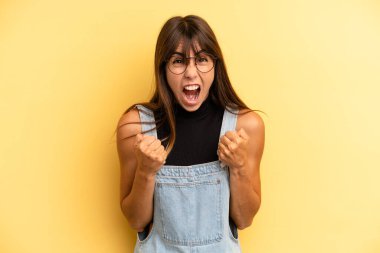 İspanyol asıllı güzel bir kadın sinirli, sinirli bakışlar ve sıkı yumruklar ile agresif bir şekilde bağırıyor.