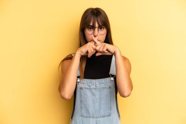 Latin kökenli güzel bir kadın ciddi görünüyor ve iki parmağının önde olması hoşnutsuzca karşılıyor. Sessizlik istiyor.