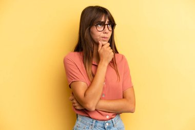 İspanyol güzel kadın düşünüyor, kuşkulu ve şaşkın hissediyor, farklı seçeneklerle, hangi kararı vereceğini merak ediyor.