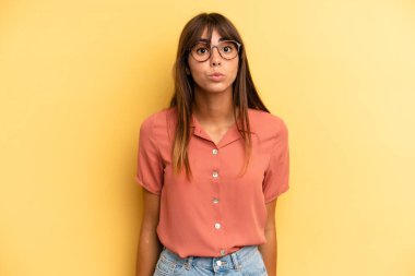 Tatlı, eğlenceli, mutlu, sevimli bir yüz ifadesiyle dudaklarını birbirine bastıran İspanyol güzeli bir kadın öpücük yolluyor.