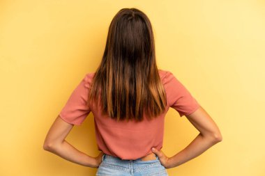 Hispanik güzel kadın kafası karışık ya da dolu ya da şüphe ve sorular, merak, elleri kalçasında, dikiz görüşlü