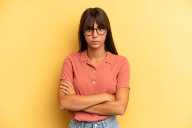 İspanyol güzel bir kadın hayal kırıklığına uğramış, hayal kırıklığına uğramış, ciddi görünüyor, kızgın ve kollarını kavuşturmuş.