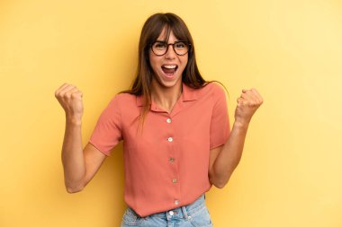 İspanyol güzel kadın mutlu, pozitif ve başarılı hissediyor, zaferi, başarıları veya iyi şansı kutluyor.