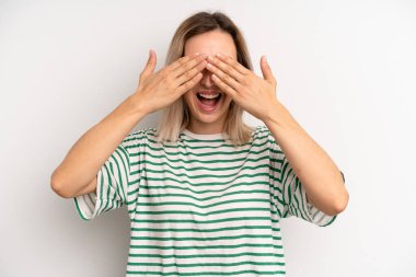 Genç sarışın kadın gülümsüyor ve mutlu hissediyor, iki eliyle gözlerini kapatıyor ve inanılmaz bir sürpriz bekliyor.