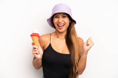 Asyalı genç kadın şokta, gülüyor ve başarıyı kutluyor. yaz ve dondurma konsepti