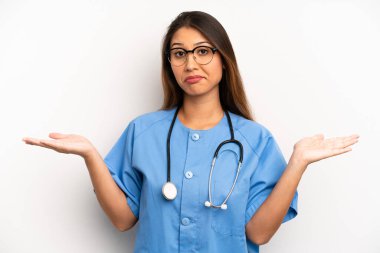 Asyalı genç kadın şaşkın, şaşkın ve şüpheci hissediyor. hemşire ya da doktor konsepti
