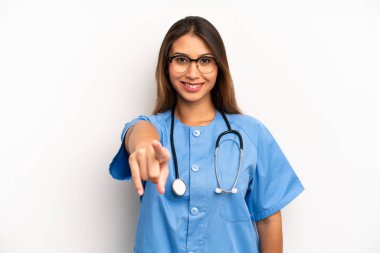 Asyalı genç bir kadın kamerayı işaret ederek seni seçiyor. hemşire ya da doktor konsepti
