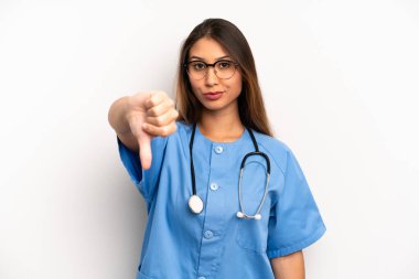 Asyalı genç bir kadın kendini kötü hissediyor, baş parmağını kaldırıyor. hemşire ya da doktor konsepti