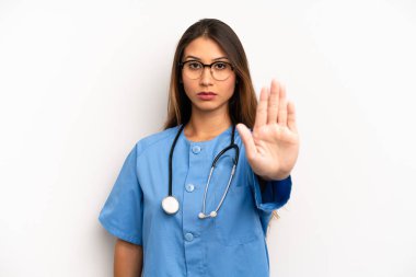 asian young woman looking serious showing open palm making stop gesture. nurse or doctor concept