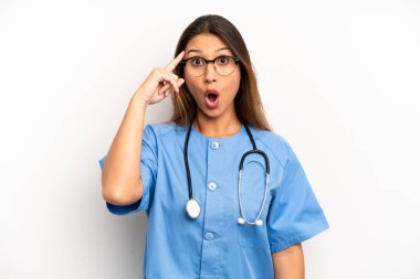 Asyalı genç kadın şaşırmış görünüyor, yeni bir düşünce, fikir ya da konsept fark ediyor. hemşire ya da doktor konsepti
