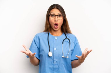 asian young woman feeling extremely shocked and surprised. nurse or doctor concept