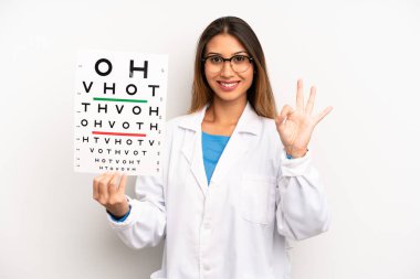 asian young woman feeling happy, showing approval with okay gesture. optical vision test concept