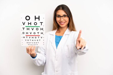 asian young woman smiling proudly and confidently making number one. optical vision test concept