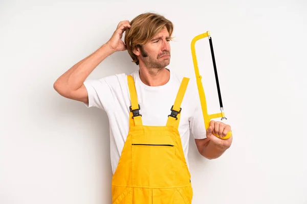 Adult Blond Man Smiling Happily Daydreaming Doubting Handyman Saw Concept — Stock Photo, Image