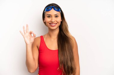 Asyalı genç bir kadın kendini mutlu hissediyor, iyi bir jestle onaylıyor. yüzücü kavramı