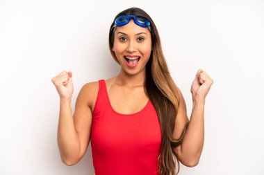 Asyalı genç kadın şokta, gülüyor ve başarıyı kutluyor. yüzücü kavramı